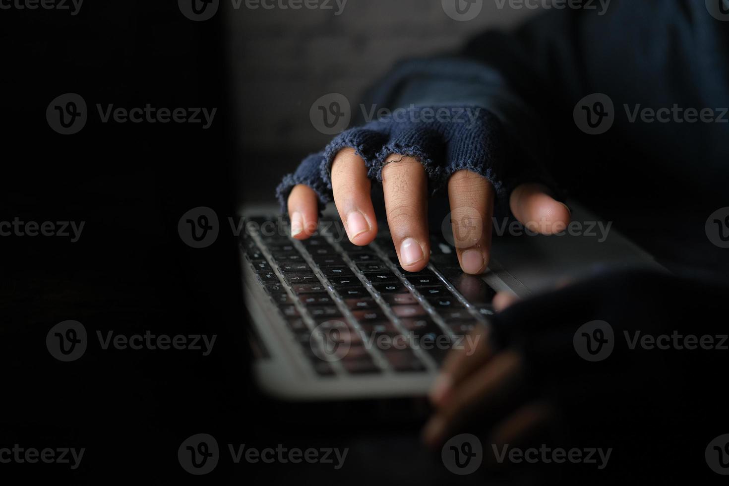 mano di hacker che ruba dati dal laptop dall'alto verso il basso foto
