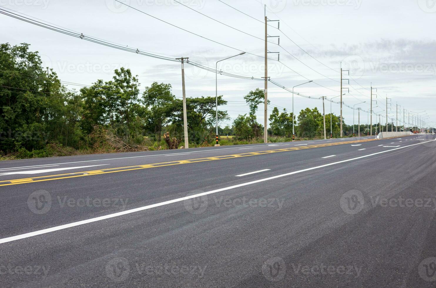 Visualizza di nuovo asfalto strada con bianca frecce e altro simboli allungamento. foto