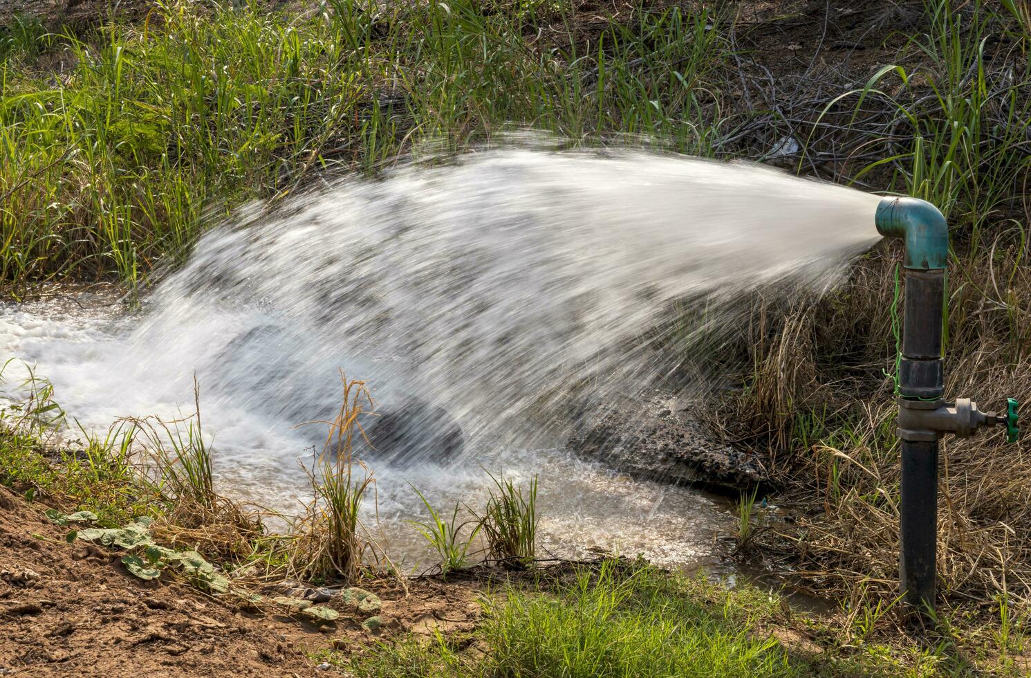 avvicinamento Visualizza di acqua zampillante violentemente su di un' acqua fornitura tubo. foto