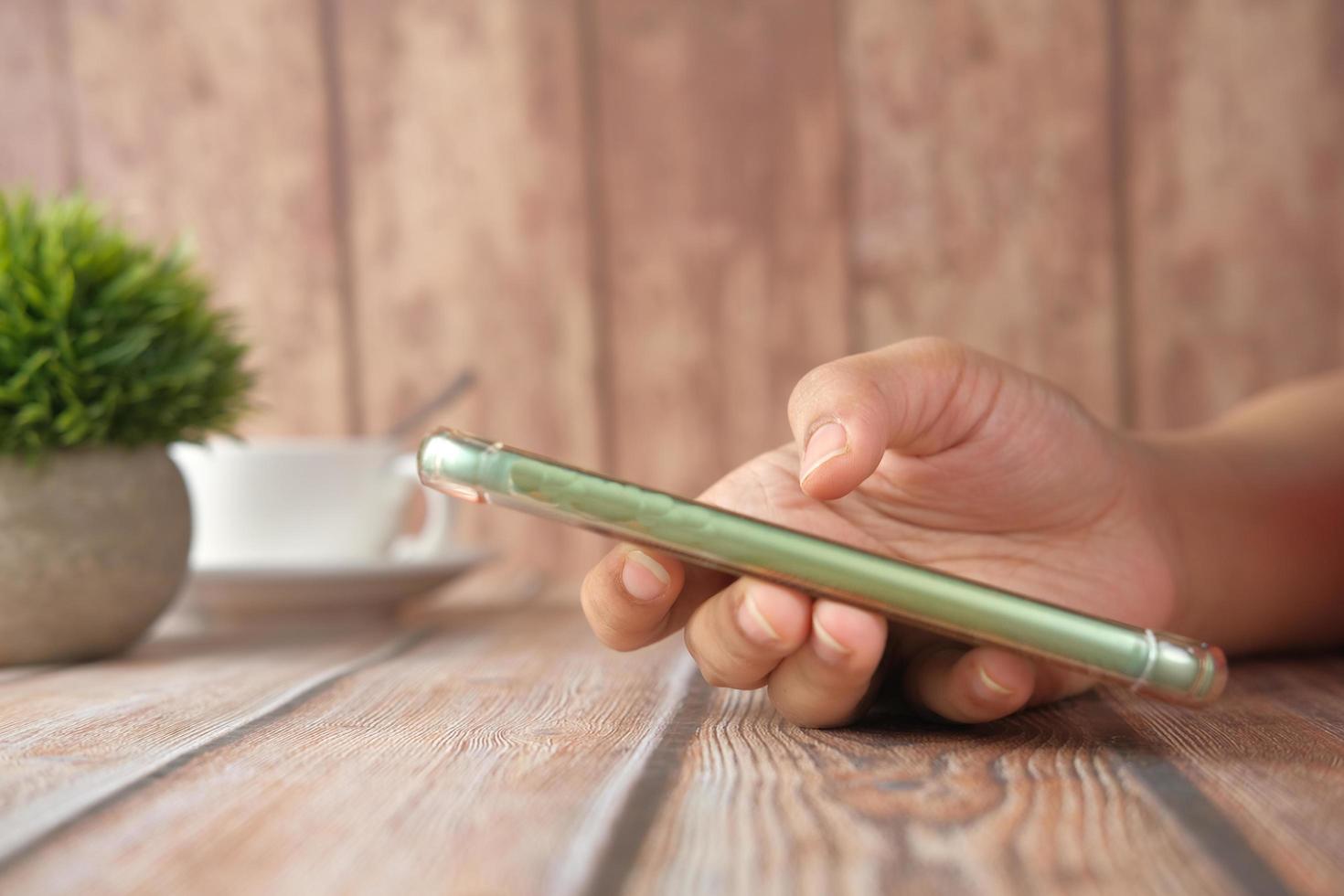 primo piano di una donna che tiene in mano uno smartphone foto