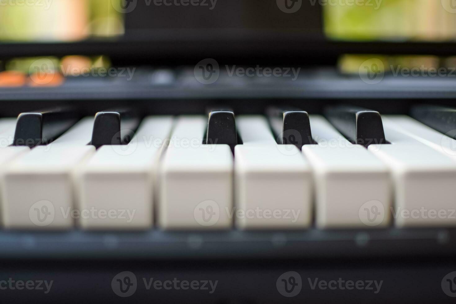 avvicinamento di pianoforte chiavi. pianoforte nero e bianca chiavi e pianoforte tastiera musicale strumento posto a il casa balcone durante soleggiato giorno. foto