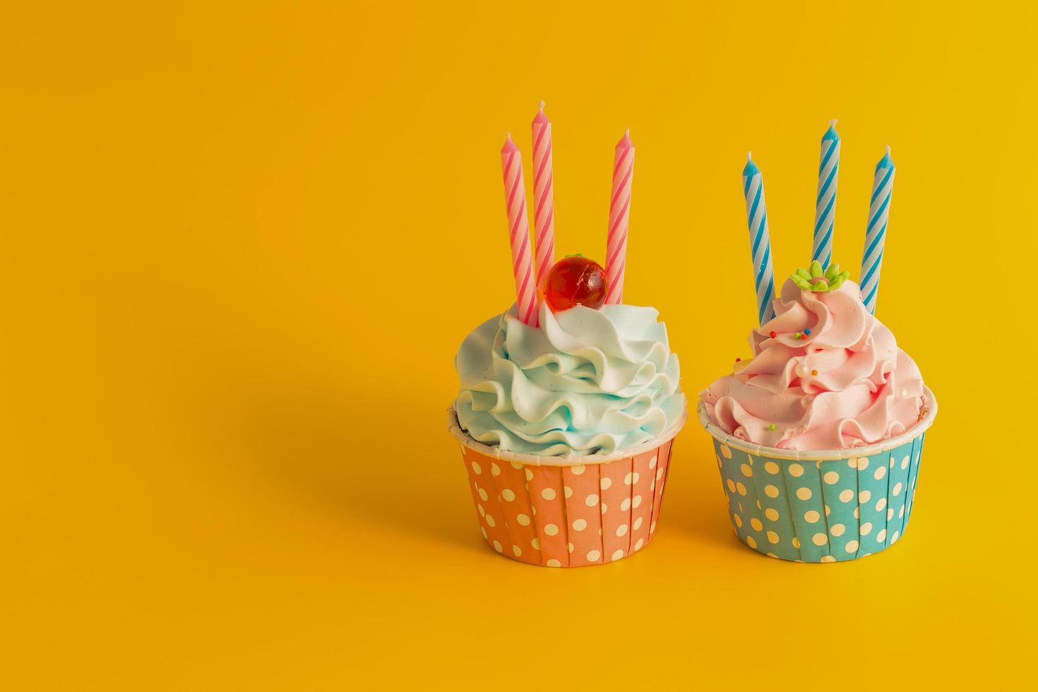 gustoso cupcake di compleanno con candele su sfondo di colore giallo foto
