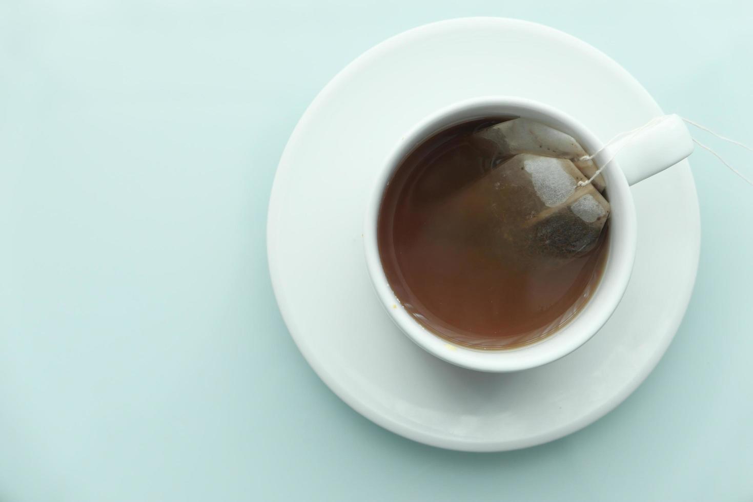 tè verde con bustina di tè su sfondo di piastrelle foto