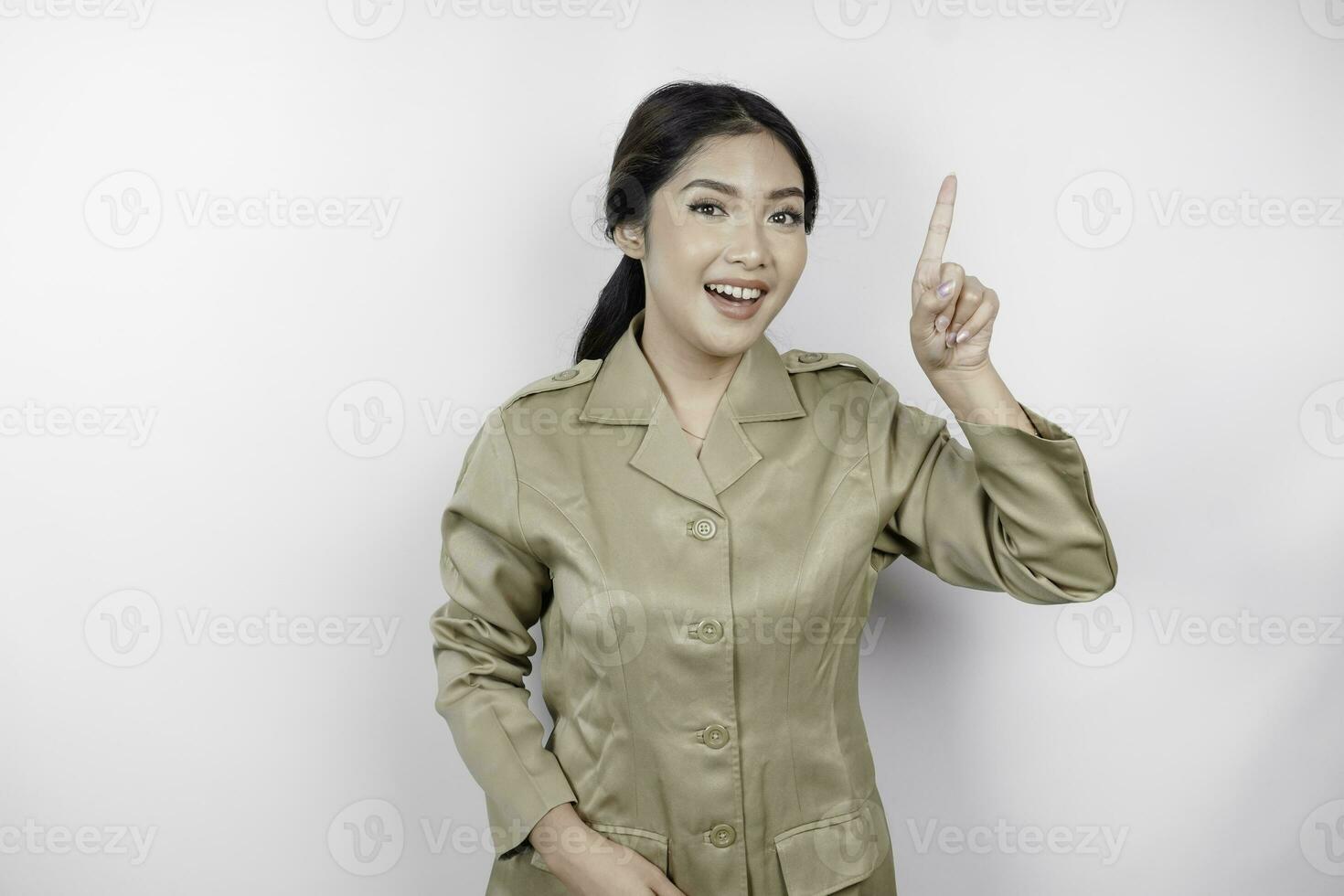 sorridente bellissimo asiatico donna puntamento dito per vuoto spazio sopra sua nel studio bianca isolato sfondo foto