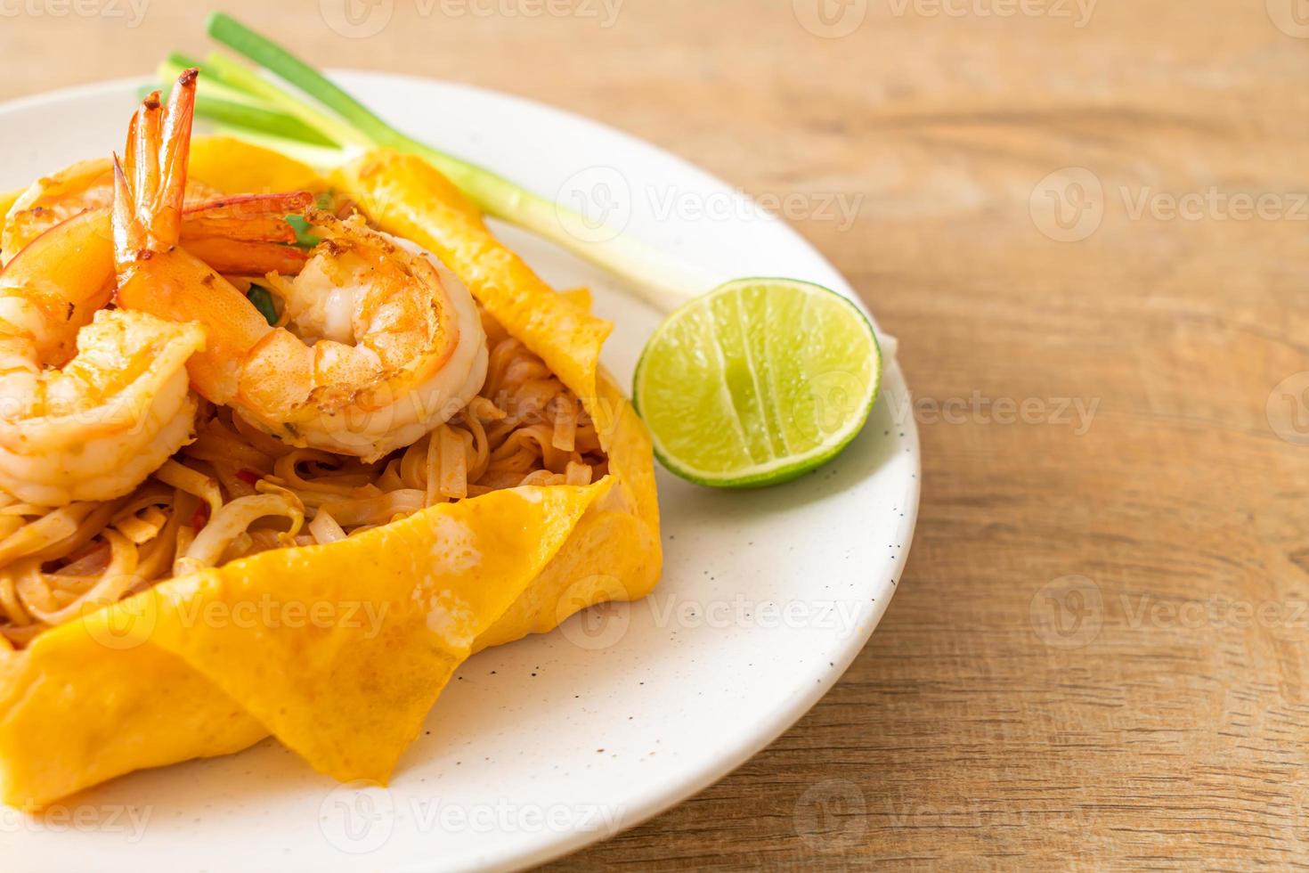 noodles saltati in padella con gamberi e involucro di uova o pad thai foto