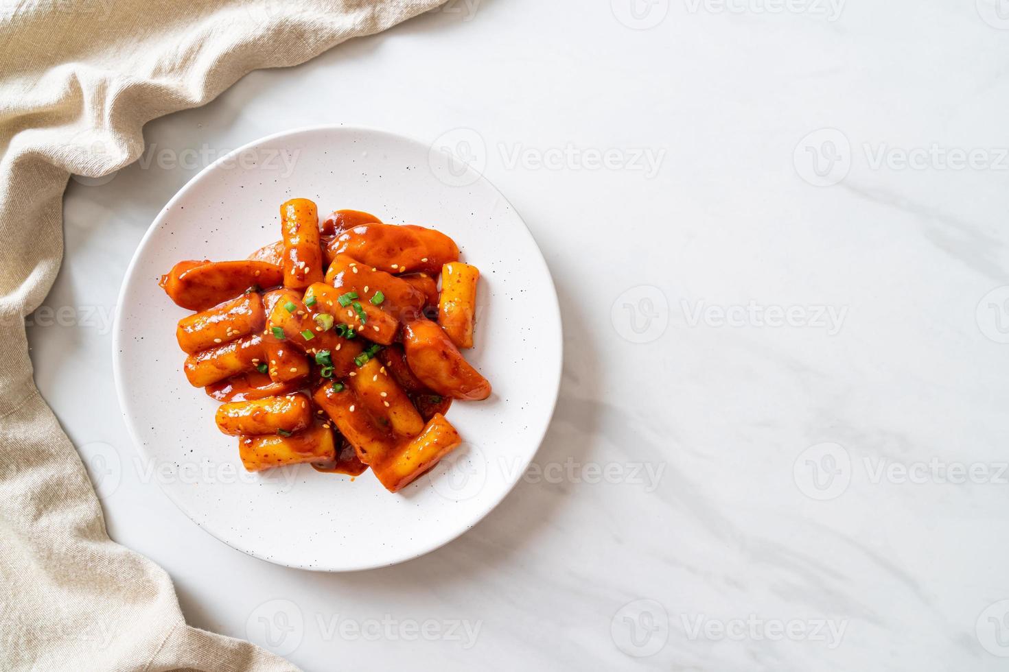 Stecco di torta di riso coreano con salsiccia in salsa piccante - tteokbokki foto