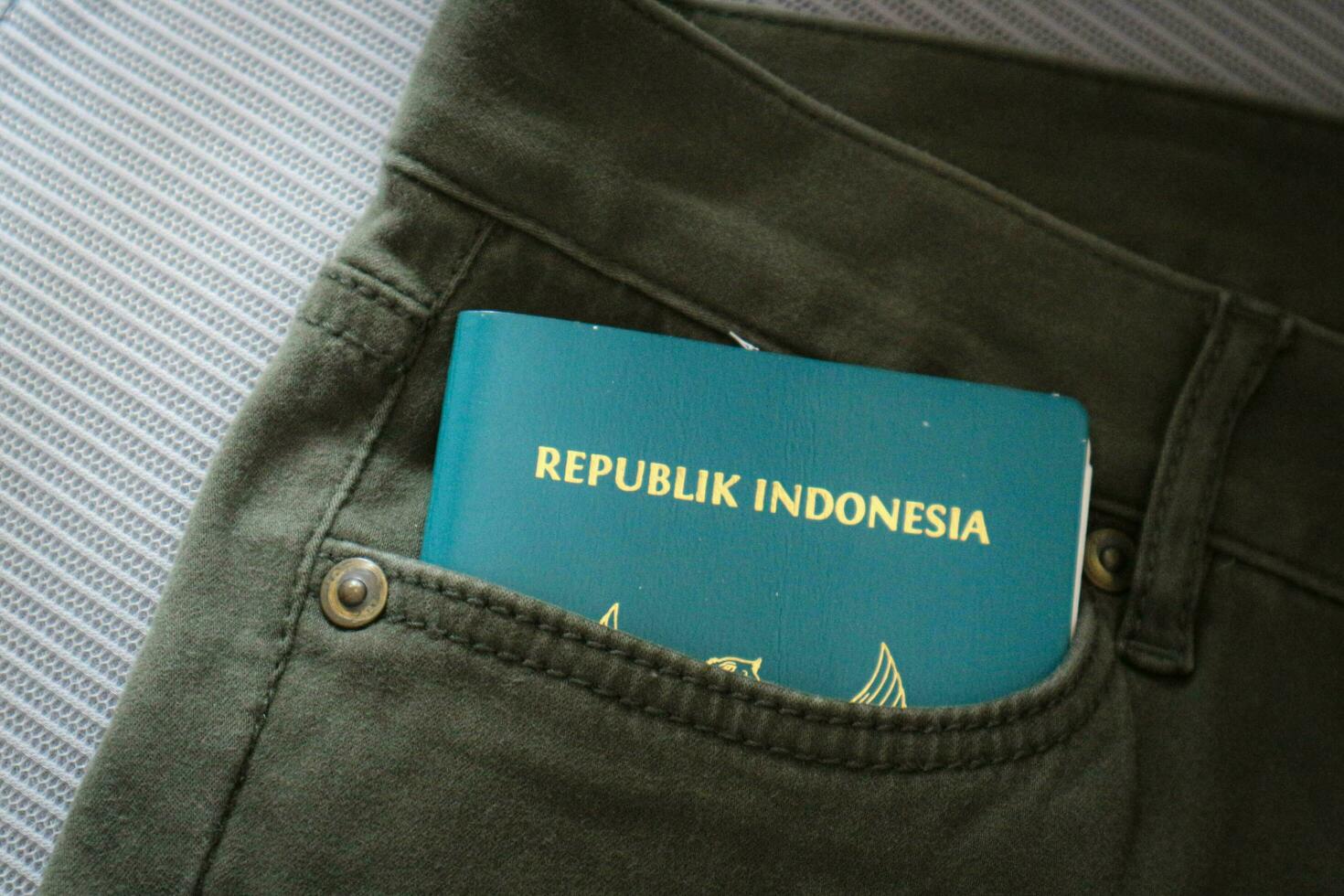 un indonesiano cittadinanza passaporto nel un' verde denim tasca. foto