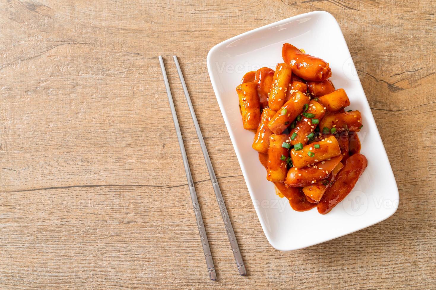 Stecco di torta di riso coreano con salsiccia in salsa piccante - tteokbokki foto