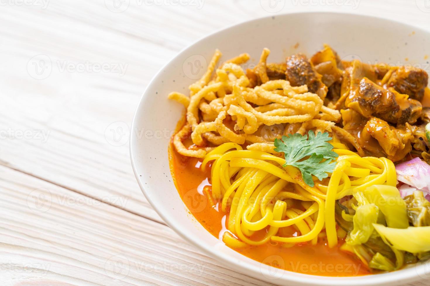 zuppa di noodle al curry del nord della Thailandia con maiale brasato foto