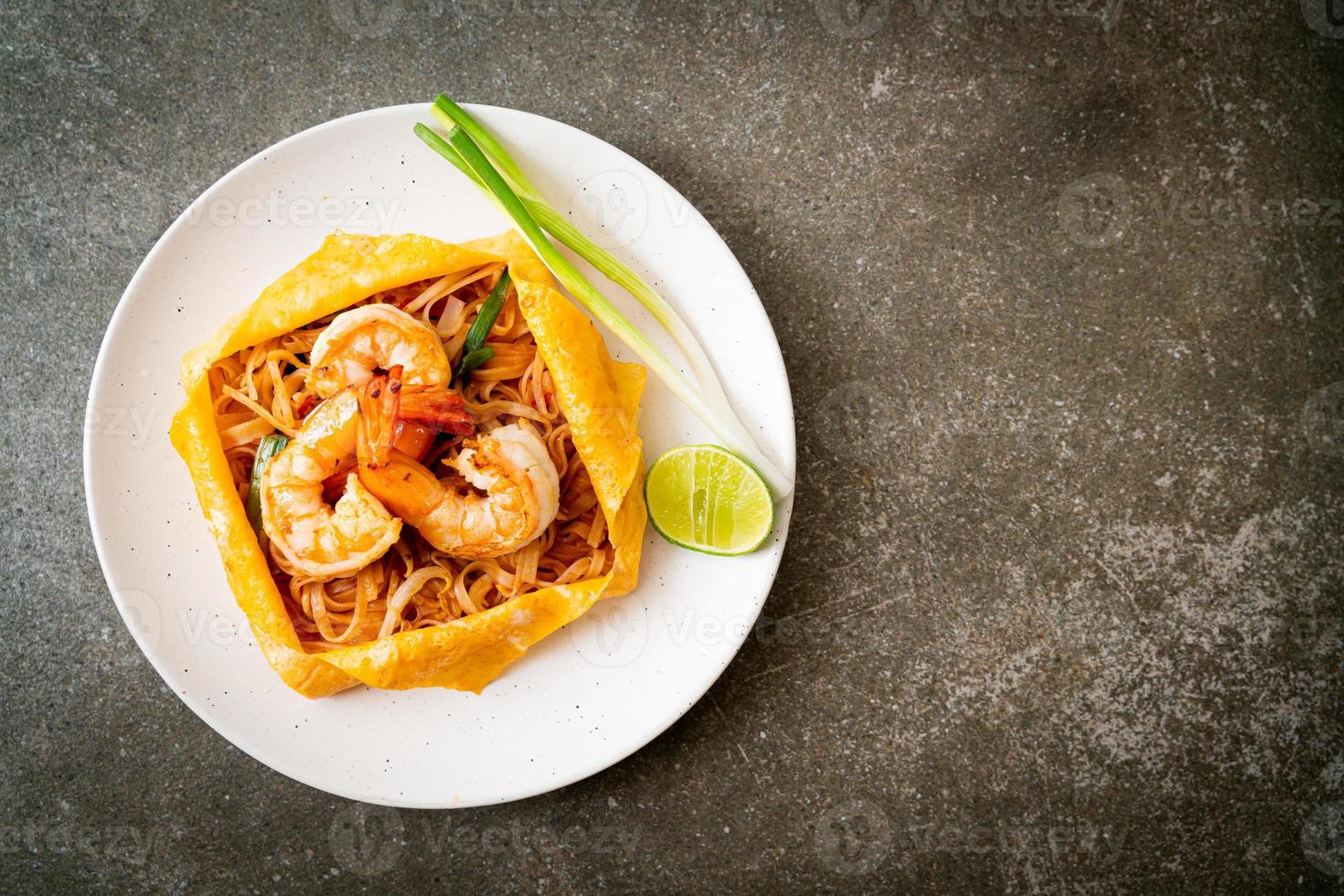 noodles saltati in padella con gamberi e involucro di uova o pad thai foto