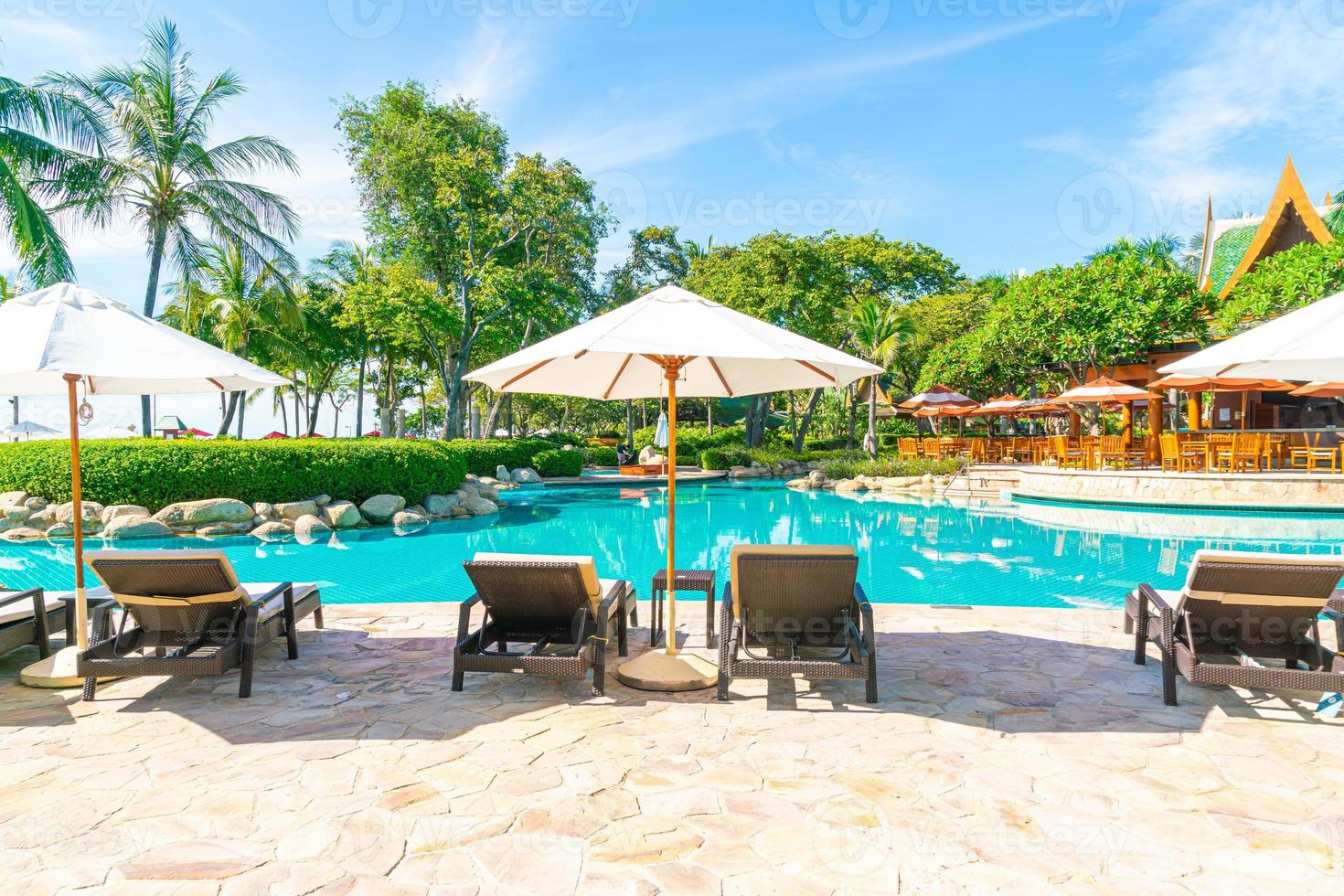 bellissimo ombrellone e sedia intorno alla piscina in hotel e resort foto