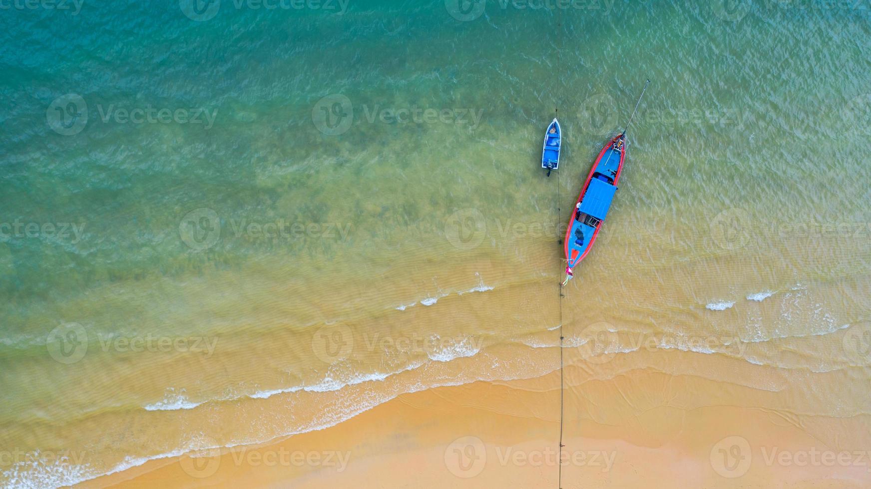 vista aerea dall'alto, barca da pesca, barca turistica che galleggia su un mare limpido poco profondo, bella acqua blu brillante nell'oceano foto