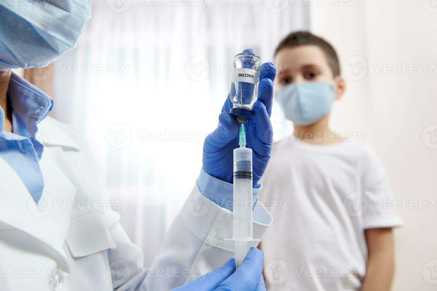 medico nel protettivo guanti Riempimento iniezione siringa con vaccino . sfocato ragazzo su il backround foto