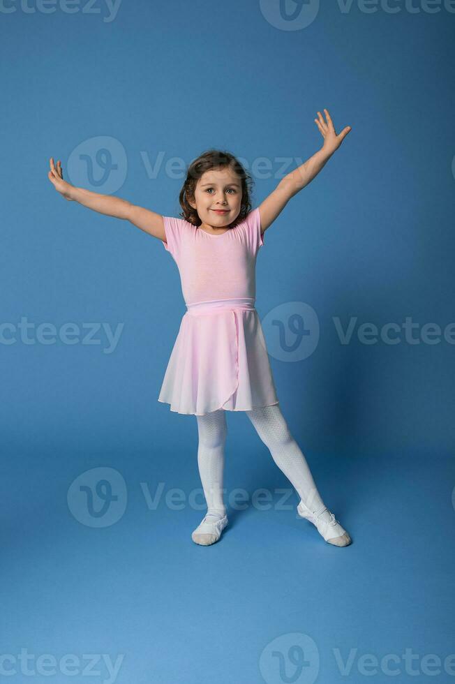 pieno lunghezza ritratto di bellissimo bambino ballerina l'esecuzione balletto danza isolato su blu sfondo con copia spazio foto