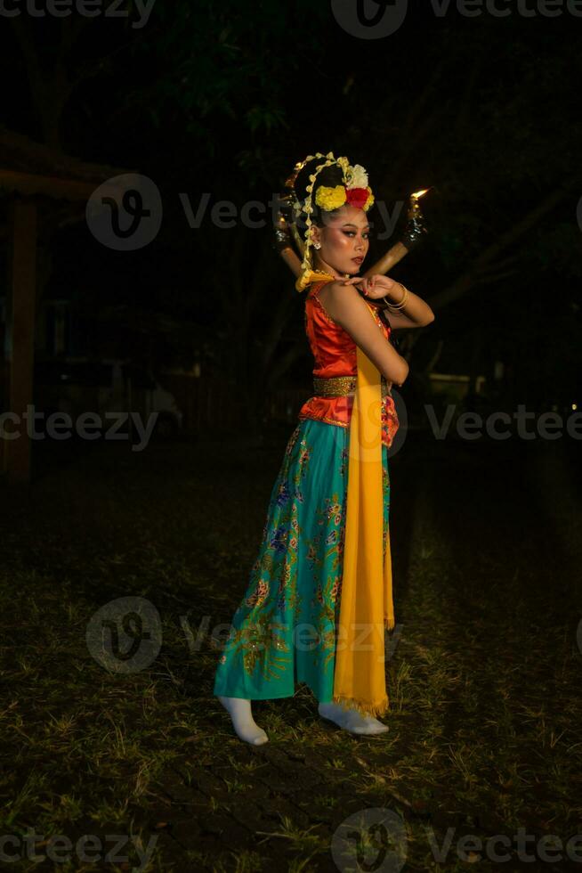 un' giavanese ballerino pose con acuto occhi e un' d'oro costume su palcoscenico foto