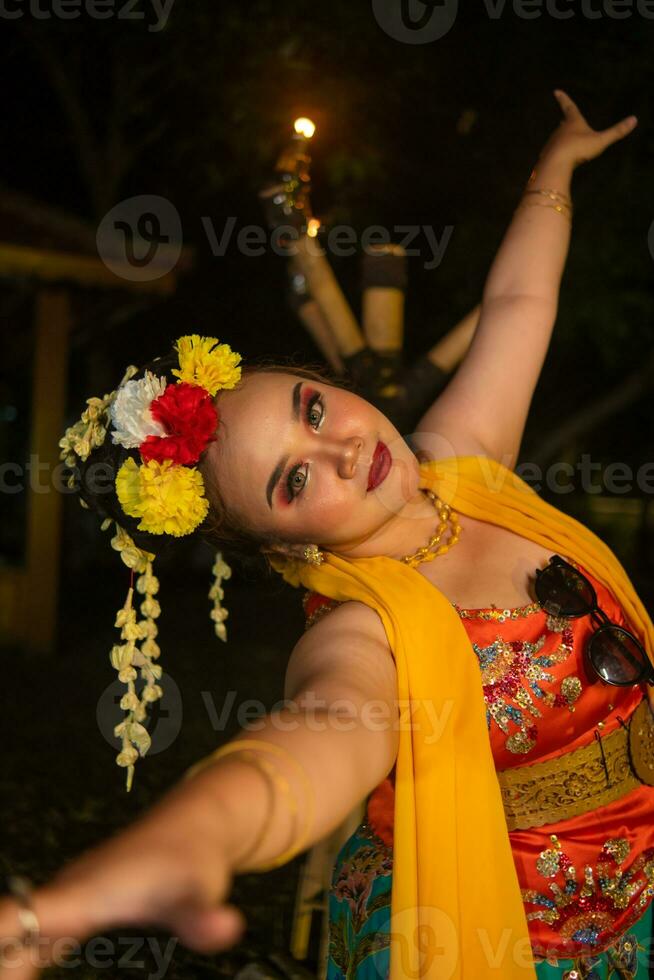 ritratto di un indonesiano ballerino con un' oro cintura danza con grazia foto