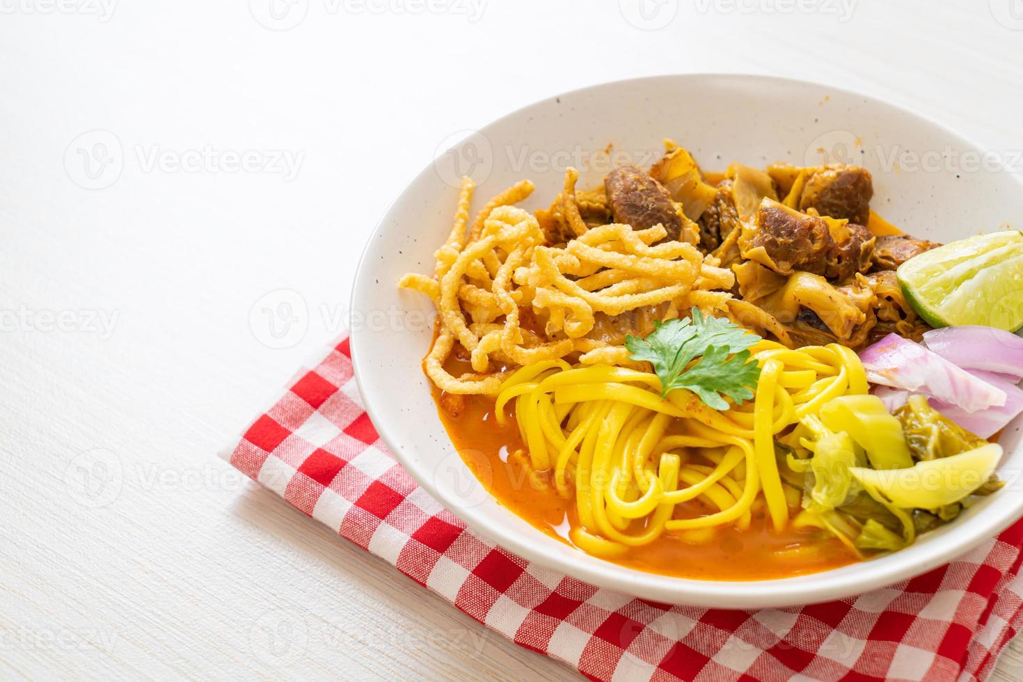 zuppa di noodle al curry del nord della Thailandia con maiale brasato foto