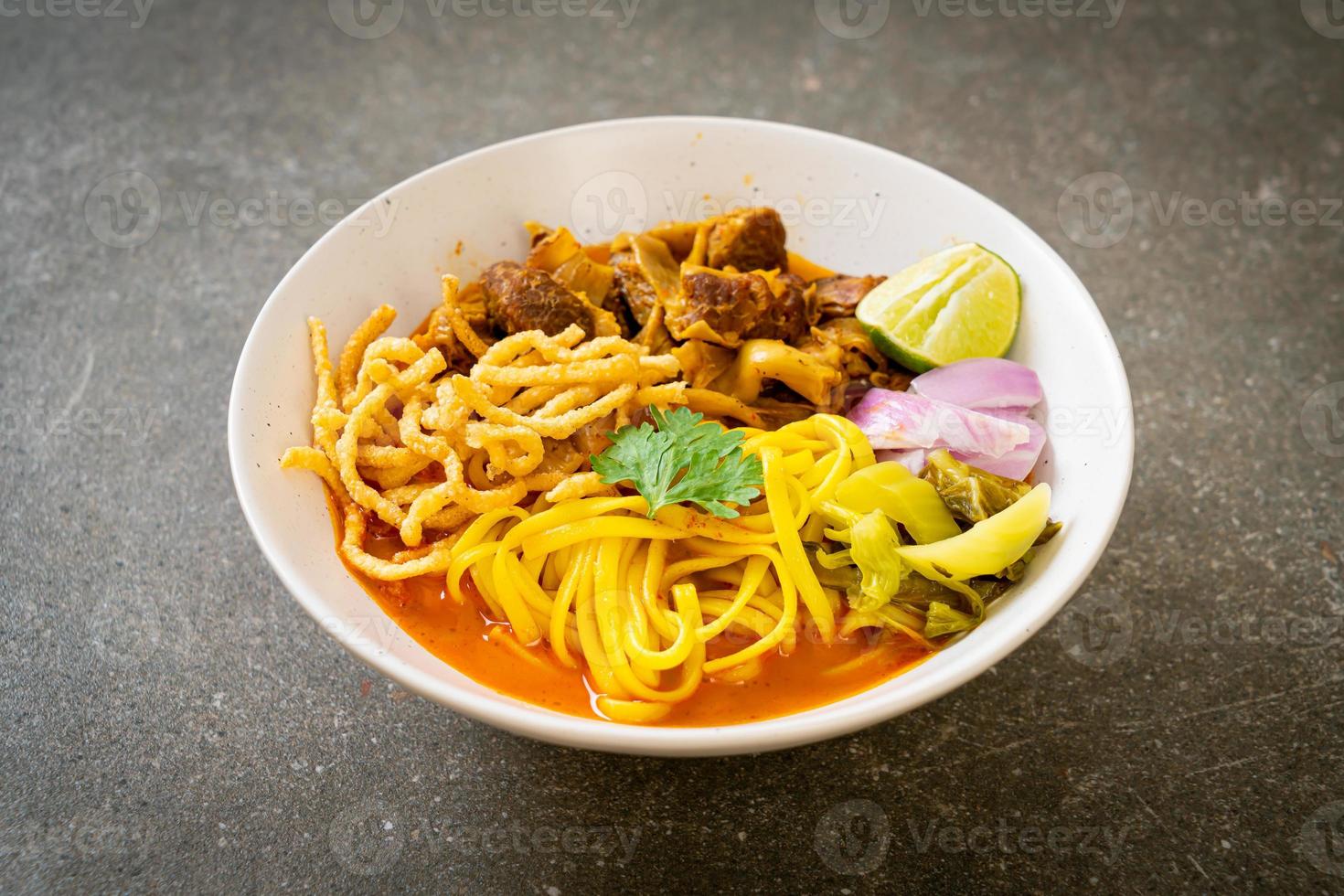 zuppa di noodle al curry del nord della Thailandia con maiale brasato foto