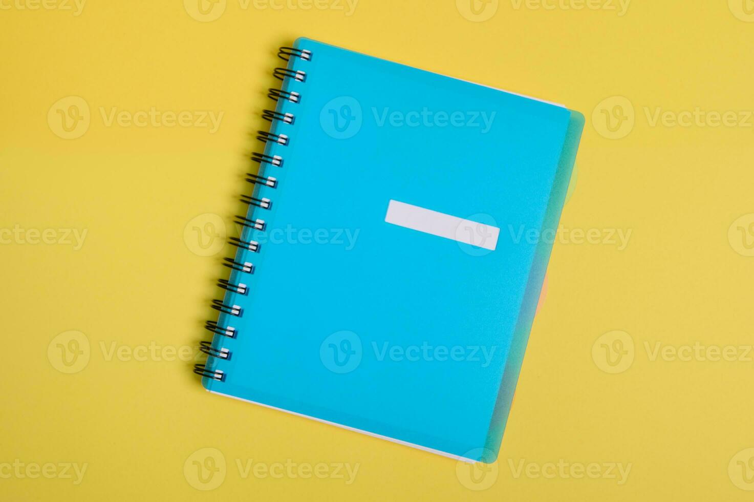 avvicinamento di un' blu colorato organizzatore, bloc notes con vuoto vuoto foglio per testo, isolato su giallo sfondo con copia spazio. piatto posare foto