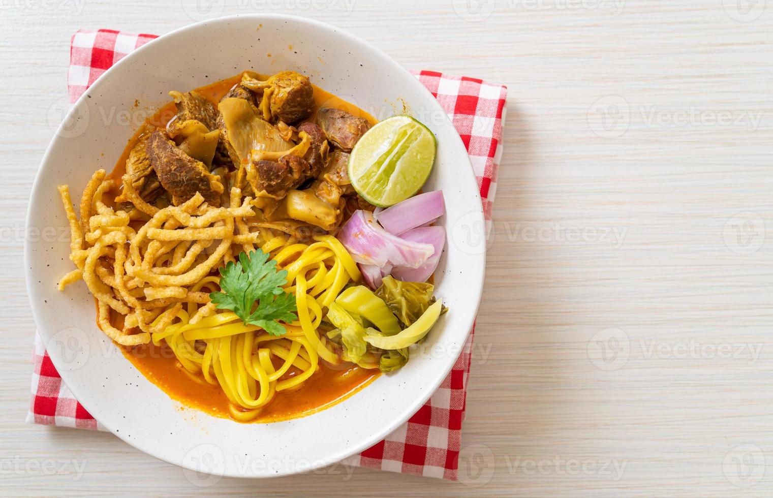 zuppa di noodle al curry del nord della Thailandia con maiale brasato foto