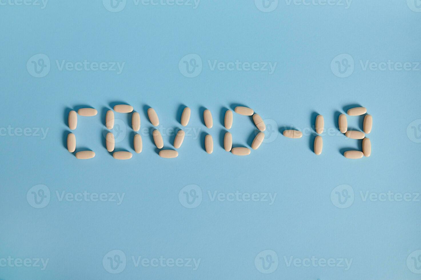 iscrizione covid-19 a partire dal lettere a partire dal medico pillole su un' blu sfondo foto