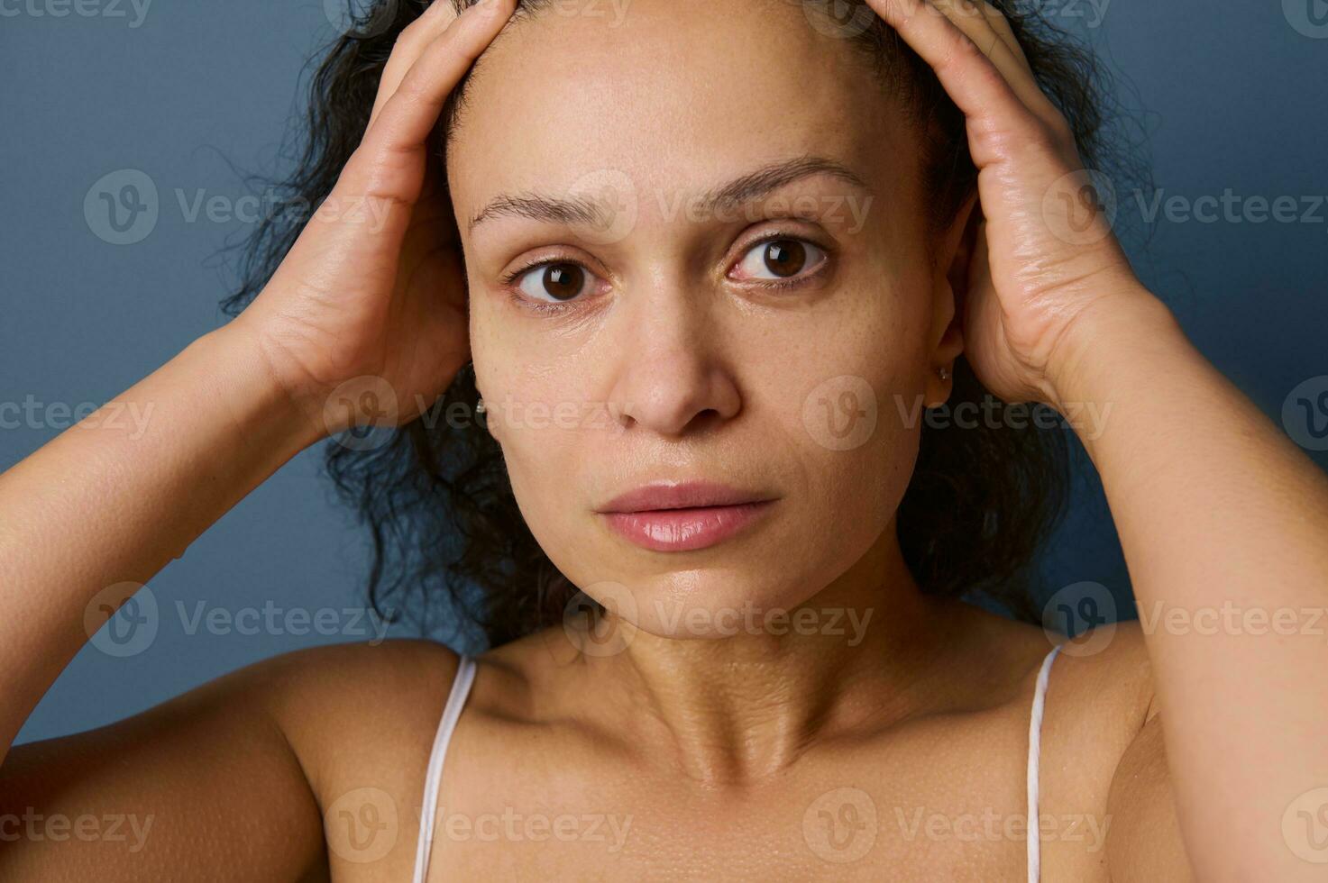 avvicinamento ritratto di mezzo anziano donna con no trucco e bagnato pelle guardare a telecamera mentre lavaggio sua viso, assunzione cura di sua bellezza e pelle. freschezza, purezza, purificare, rimozione trucco concetto foto