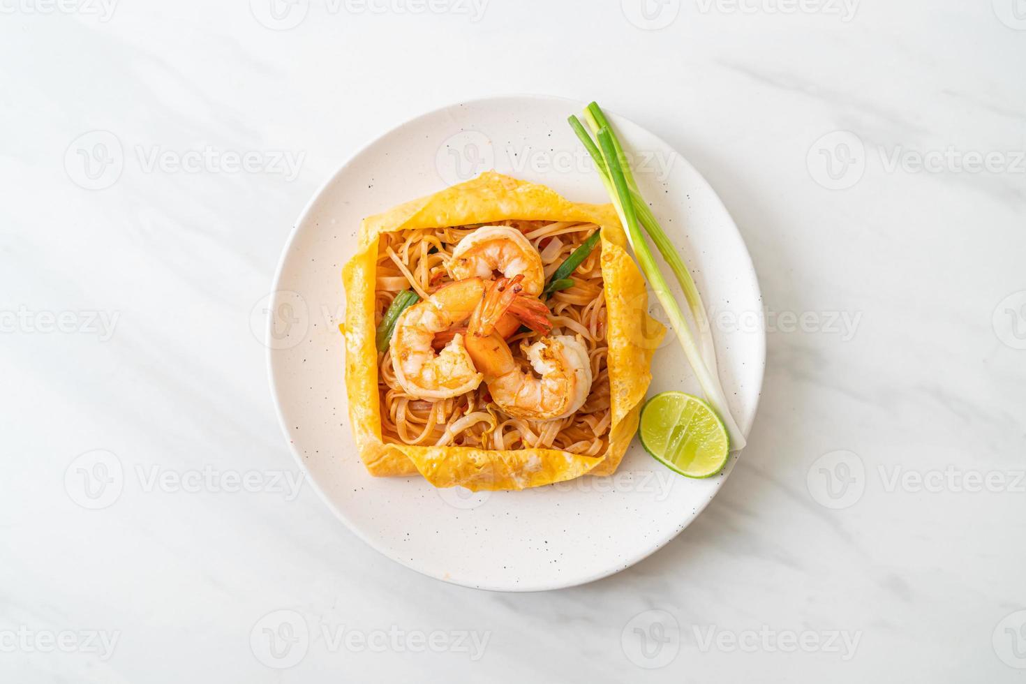 noodles saltati in padella con gamberi e involucro di uova o pad thai foto