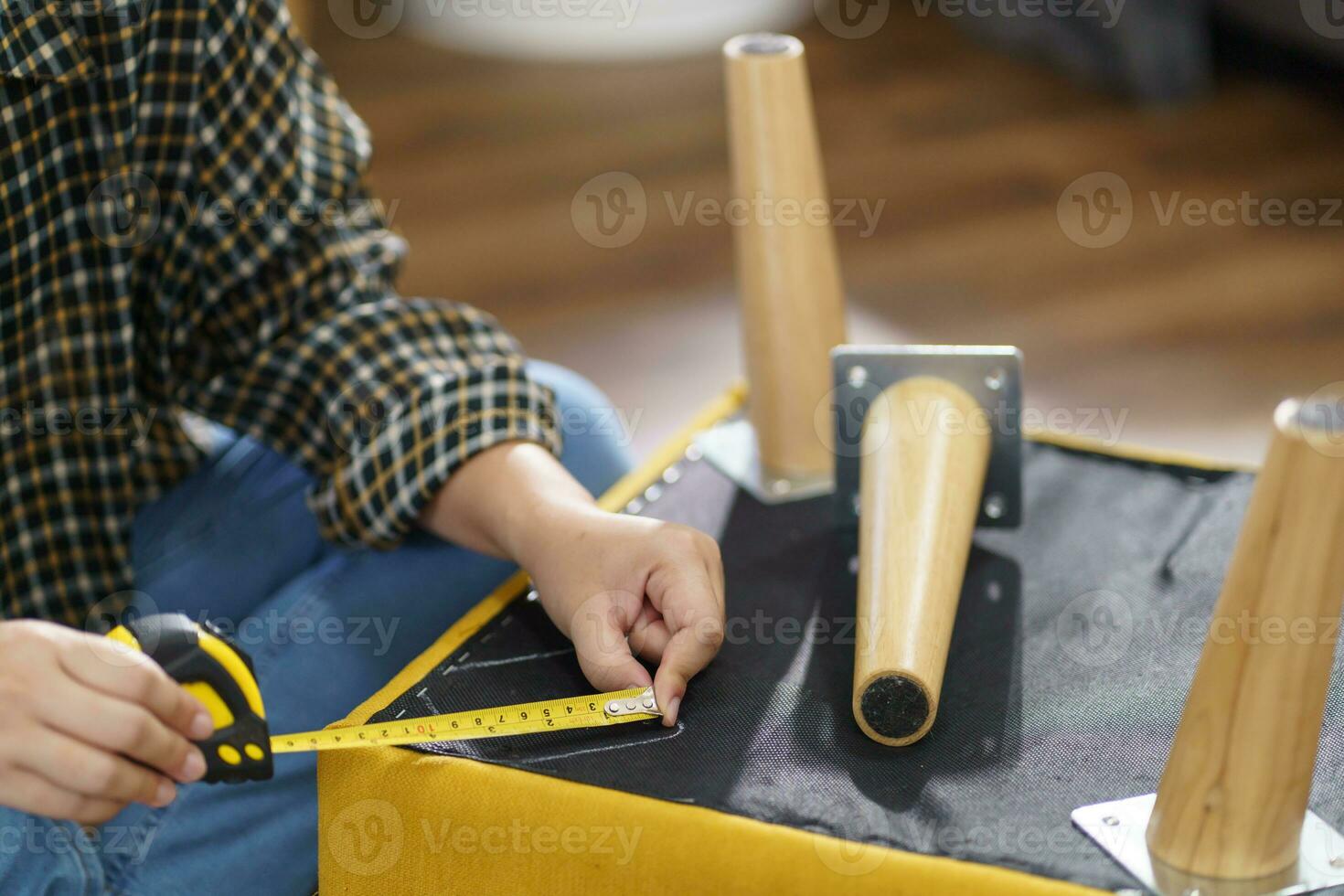 asiatico donna se stesso riparazione mobilia rinnovamento utilizzando attrezzatura per Fai da te riparazione mobilia seduta su il pavimento a casa foto
