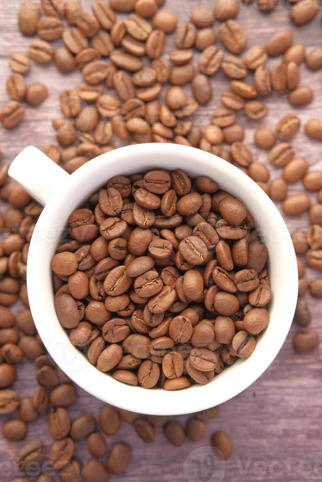 primo piano di chicchi di caffè freschi in una tazza su sfondo nero con spazio di copia foto