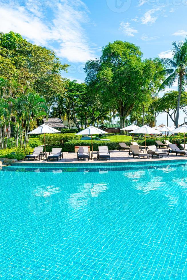 bellissimo ombrellone e sedia intorno alla piscina in hotel e resort foto