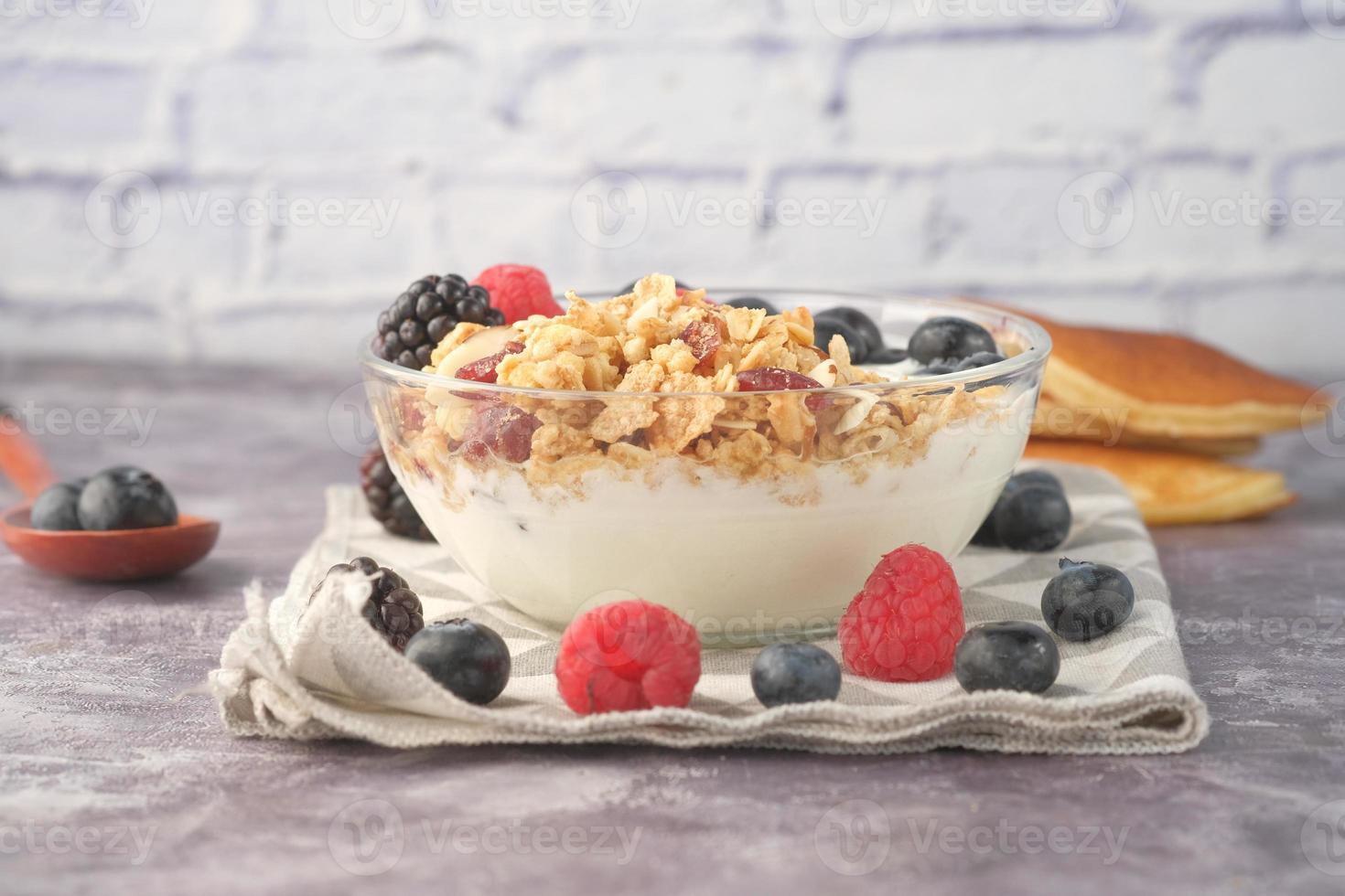 muesli e frutti di bosco in una ciotola su sfondo rosa foto