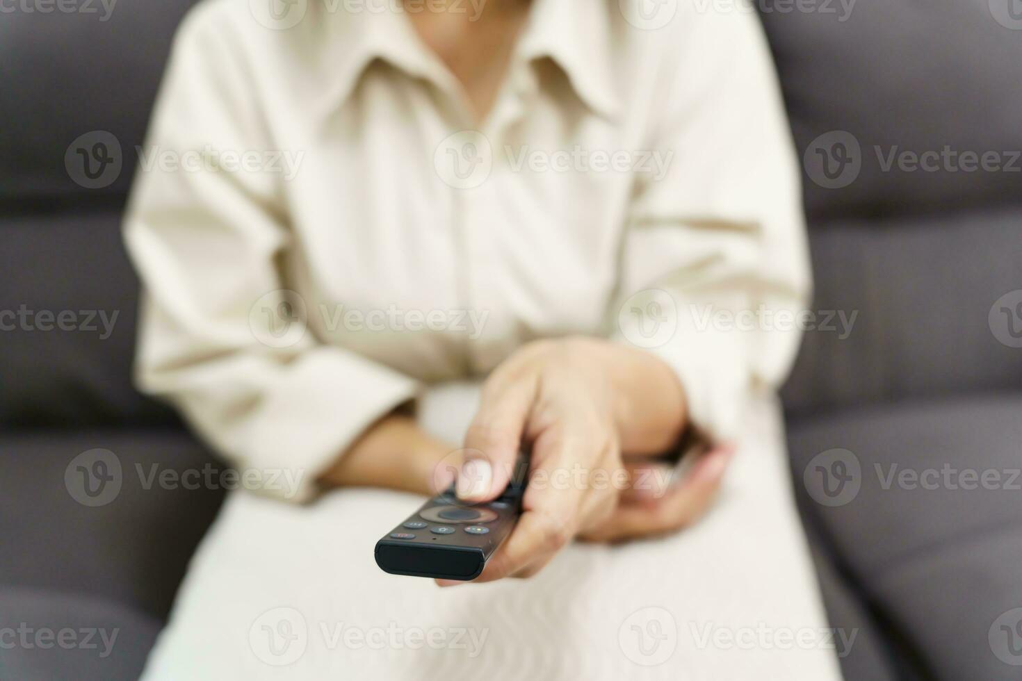 anziano donna Guardando inteligente tv e utilizzando a distanza controllore mano Tenere televisione Audio a distanza controllo mezzo età asiatico donna film televisione serie la spesa tempo a casa foto