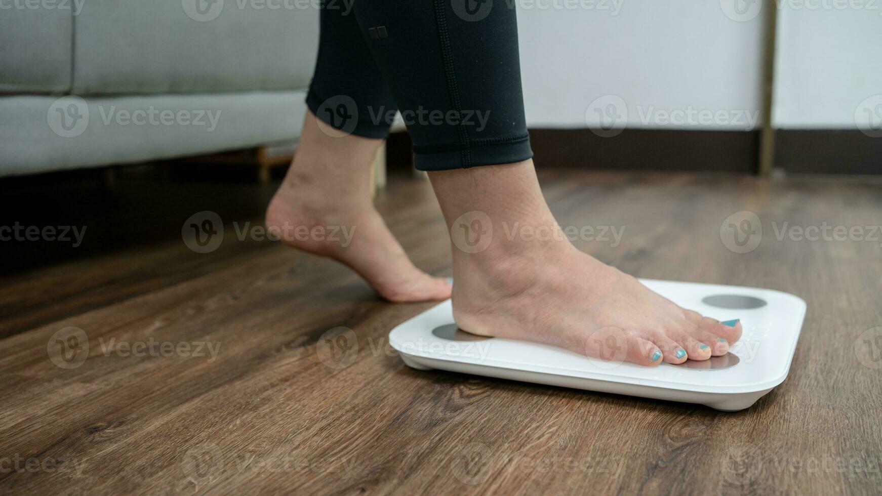 piedi in piedi su elettronico bilancia per peso controllo. misurazione strumento nel chilogrammo per un' dieta controllo foto