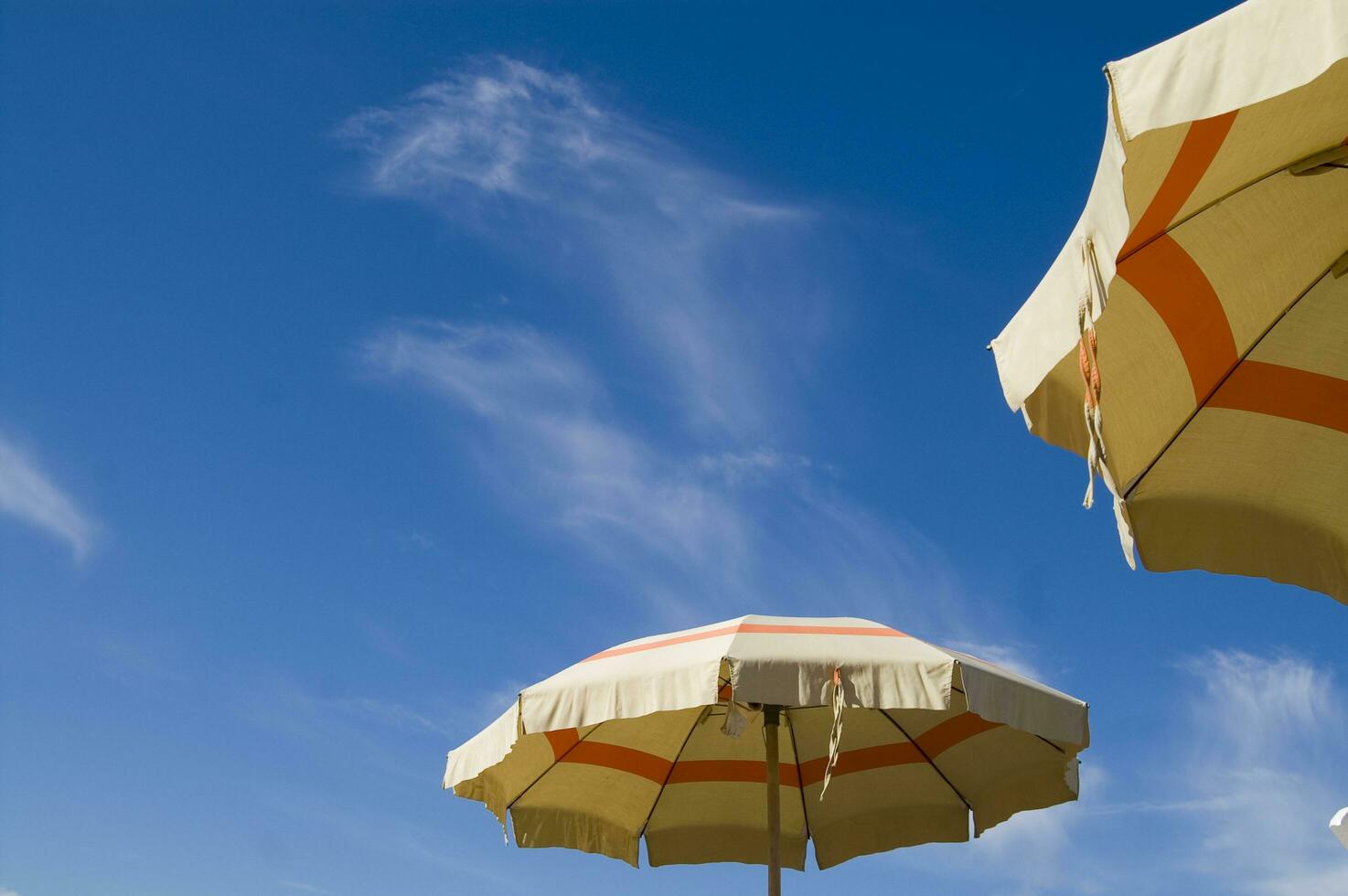 un' spiaggia ombrello con un' a strisce copertina foto