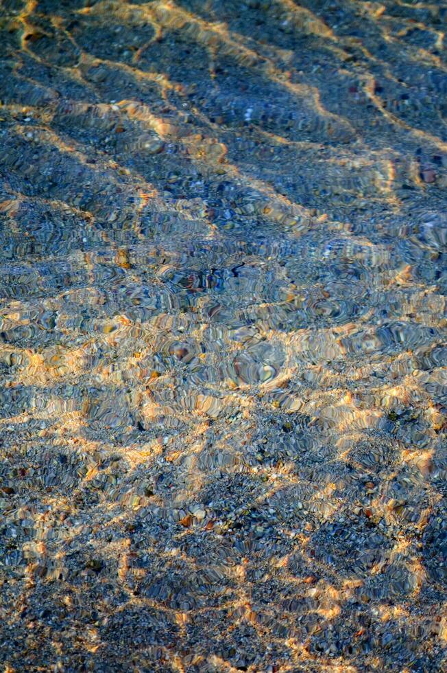 il acqua è chiaro e blu con sabbia foto