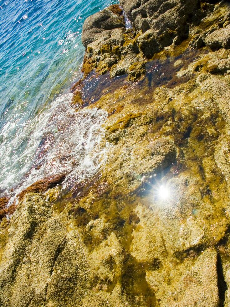 un' roccioso riva con onde Crashing contro il rocce foto