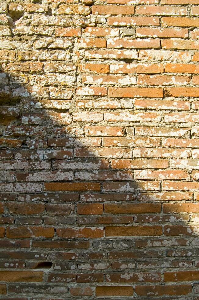 un vecchio mattone parete con un' buco nel esso foto