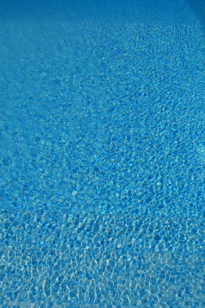 un' blu piscina con un' sole splendente su esso foto