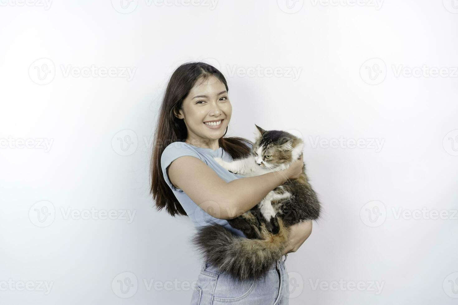 ritratto di giovane asiatico donna Tenere carino angora gatto con giallo occhi. femmina abbracciare sua carino lungo capelli gattino isolato di bianca sfondo. adorabile domestico animale domestico concetto. foto