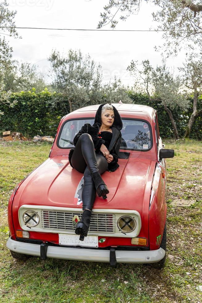 ritratto ragazza bionda capelli corti sdraiata sopra un'auto foto