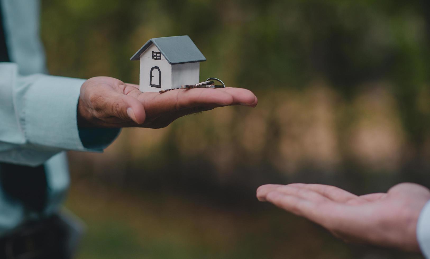 mano dando chiave casa affari vendita affitto assicurazione foto