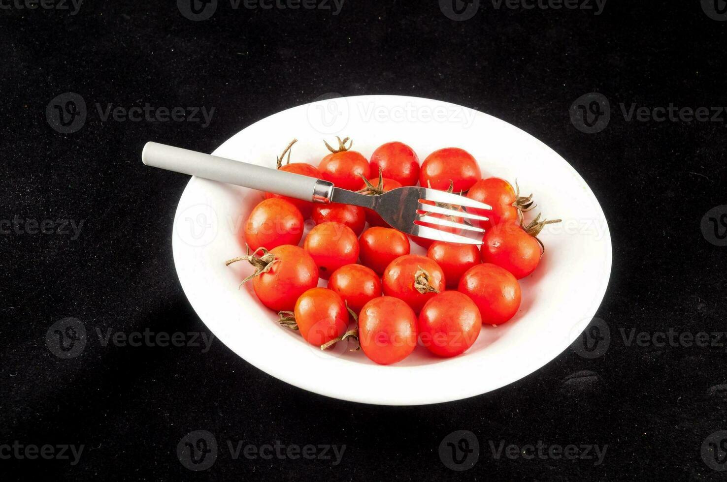 un' forchetta e un' ciotola di pomodori foto