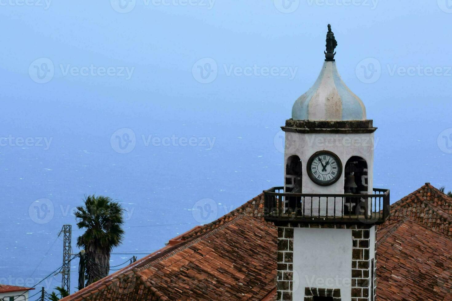 un' orologio Torre su superiore di un' edificio prospiciente il oceano foto