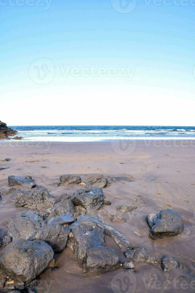 un' spiaggia con rocce e acqua su esso foto