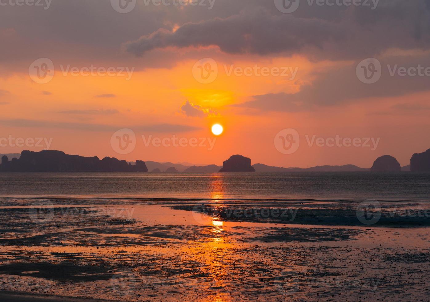 bellissimo tramonto sulla spiaggia in estate con riflesso del sole nell'acqua foto