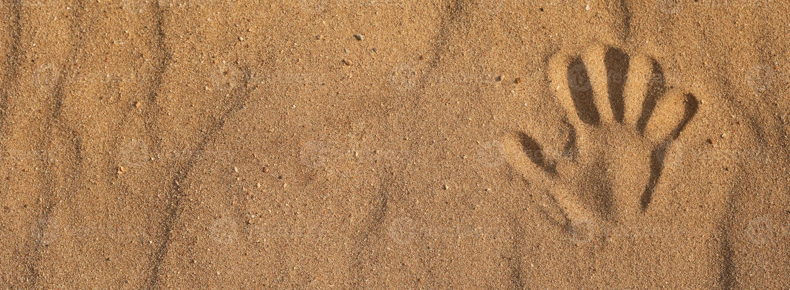 striscione impronta di mano sulla sabbia sulla spiaggia foto