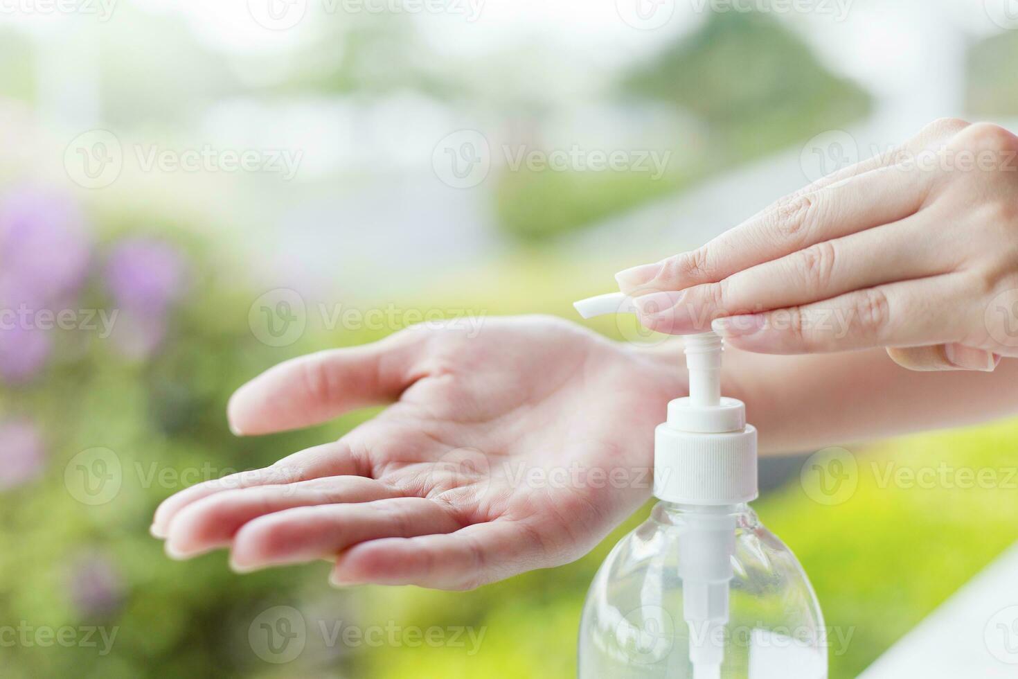 femmina mani utilizzando lavare mano disinfettante gel pompa distributore. foto