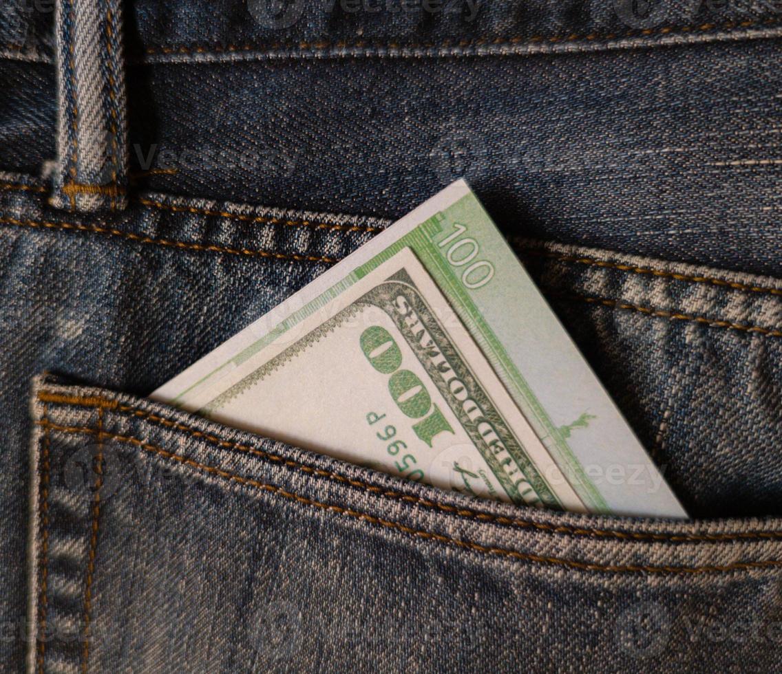 cento dollari e cento euro nella tasca posteriore dei jeans. foto