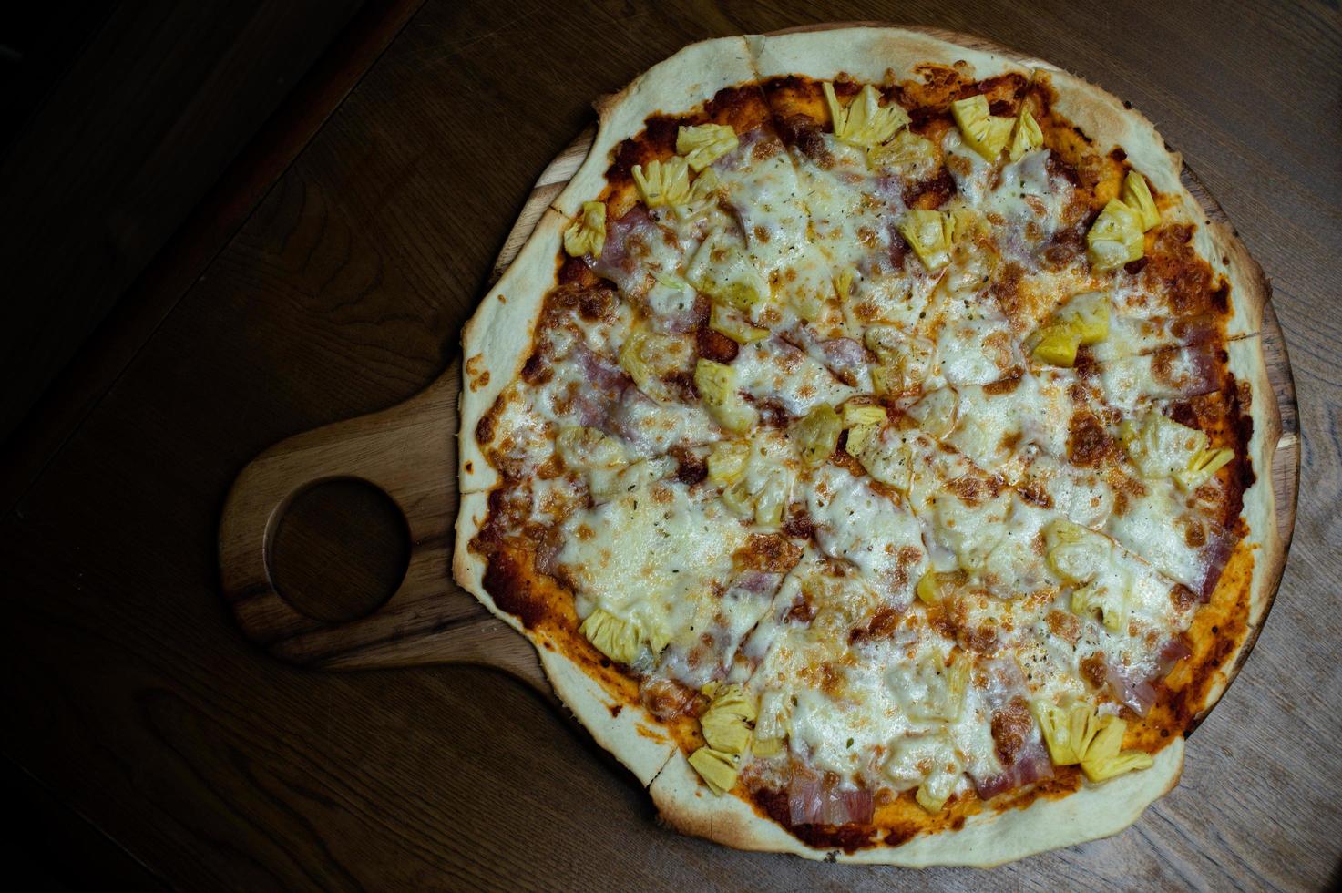 pizza, topping hawaiano, sul tavolo da pranzo foto