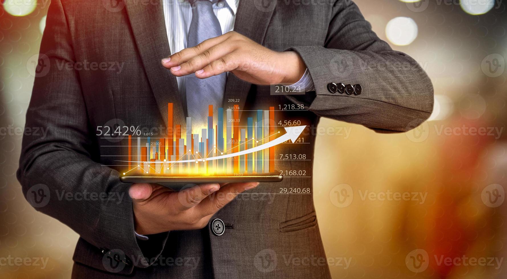 gli uomini d'affari tengono un tablet, un piano e una strategia e visualizzano ologrammi virtuali di statistiche, grafici finanziari, titoli e grafici su uno sfondo scuro. il concetto di crescita aziendale foto